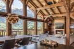 Experience luxury mountain living in this stunning chalet, featuring a grand open-plan living area with a cozy fireplace and breathtaking panoramic views of the snow-capped peaks.