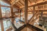 Experience luxury mountain living in this stunning chalet featuring a unique glass floor and exposed wooden beams.