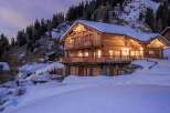 Experience the ultimate alpine retreat in this stunning wooden chalet, nestled amidst snow-covered mountains.