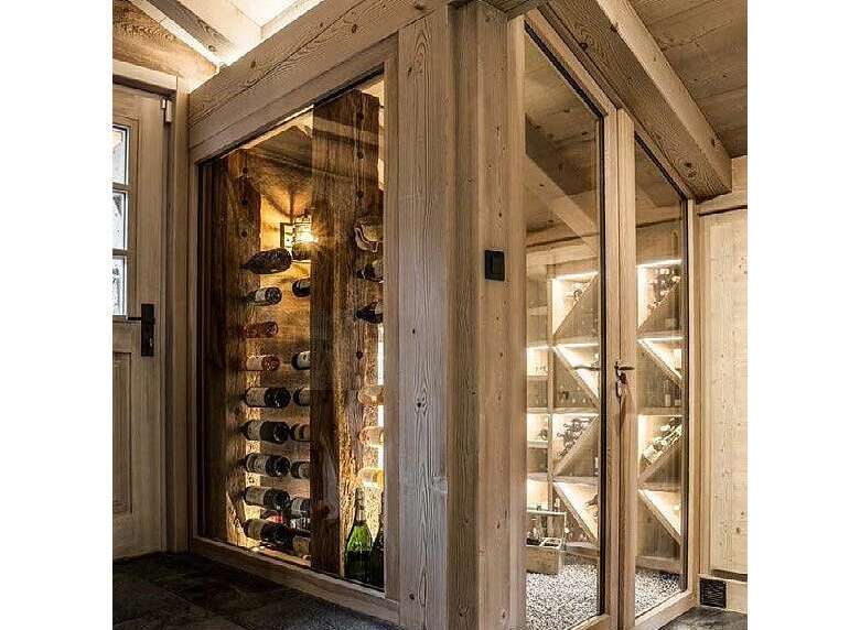 Experience the ultimate in wine storage with this custom-built wine cellar, featuring a rustic wooden interior and climate-controlled glass enclosures.