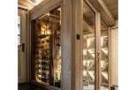 Experience the ultimate in wine storage with this custom-built wine cellar, featuring a rustic wooden interior and climate-controlled glass enclosures.