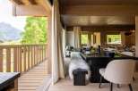 Experience luxurious mountain living in this stunning dining area, featuring a rustic wooden table set for a feast and plush, fur-covered seating.