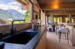 Experience the ultimate alpine retreat in this stunning kitchen, boasting a sleek black granite countertop and a modern faucet with a breathtaking mountain view.