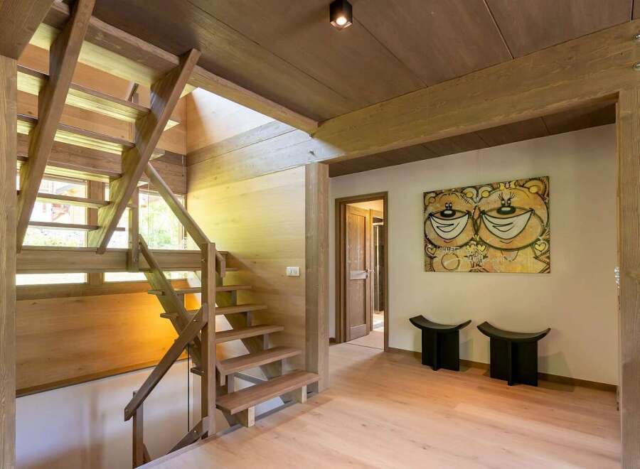 Experience rustic charm and modern design in this stunning home featuring a beautiful wooden staircase that leads to the upper levels.
