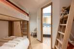 This charming bedroom features a space-saving bunk bed with a cozy, fur-covered lower bunk, perfect for children or guests.