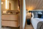 Experience modern comfort in this beautifully appointed room, featuring a sleek bathroom vanity with ample storage and a luxurious bedroom area.