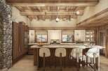 Experience rustic luxury in this stunning chalet kitchen, featuring exposed wooden beams and a grand stone fireplace.