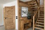 Experience rustic charm and modern comfort in this inviting entryway, featuring warm wooden doors and a stunning wooden staircase.