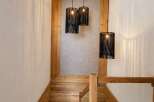 Ascend this stunning wooden staircase, bathed in the warm glow of unique black pendant lights.