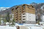 Experience luxury mountain living in this stunning multi-story residence, featuring a modern design with warm wood accents and expansive balconies perfect for enjoying breathtaking alpine views.