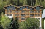 Discover this stunning multi-story wooden building nestled amidst a lush forest.