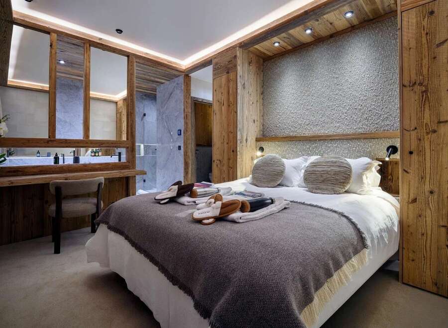 Experience luxury mountain living in this beautifully appointed bedroom, featuring a cozy king-size bed with plush linens and decorative pillows.