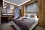 Experience luxury mountain living in this beautifully appointed bedroom, featuring a cozy king-size bed with plush linens and decorative pillows.