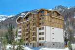 Experience luxury mountain living in this stunning property, featuring a modern wooden facade and expansive balconies perfect for enjoying breathtaking alpine views.