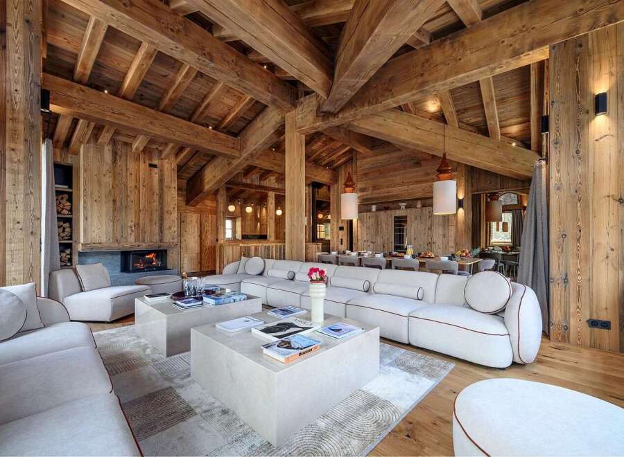 Experience luxurious mountain living in this stunning chalet, featuring a grand living area with a cozy fireplace and exposed wooden beams.