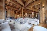 Experience luxurious mountain living in this stunning chalet, featuring a grand living area with a cozy fireplace and exposed wooden beams.