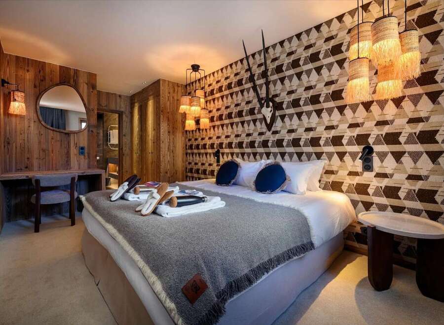 Experience rustic luxury in this charming bedroom, featuring a cozy king-size bed adorned with plush pillows and a warm, textured throw.