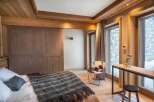 Experience rustic luxury in this charming bedroom, featuring warm wooden accents and a cozy ambiance.