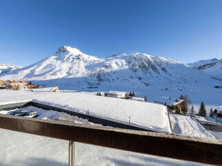 Experience the ultimate winter wonderland from this stunning property, offering breathtaking panoramic views of snow-capped mountains and a serene frozen lake.