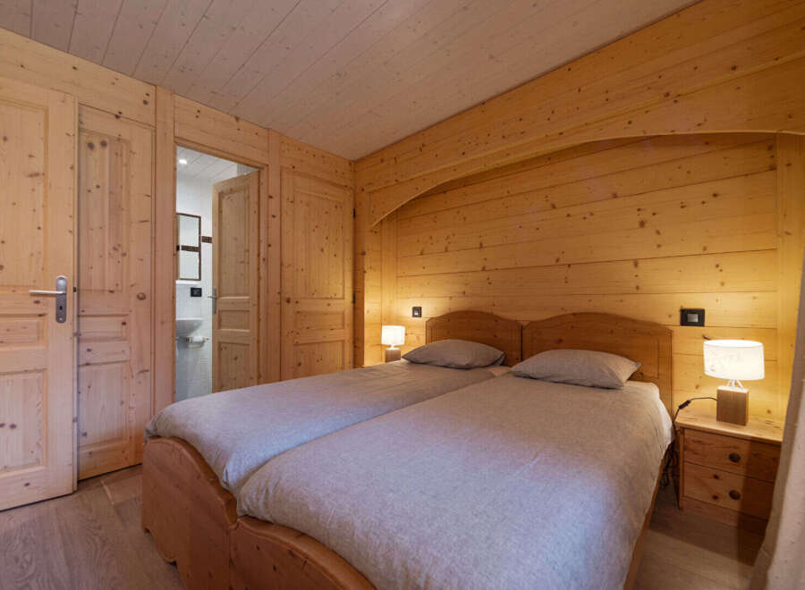 Experience rustic charm in this beautifully appointed wooden bedroom, featuring two comfortable twin beds perfect for a cozy retreat.