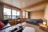 Experience breathtaking mountain views from this beautifully appointed bedroom, featuring a cozy seating area and a comfortable bed.