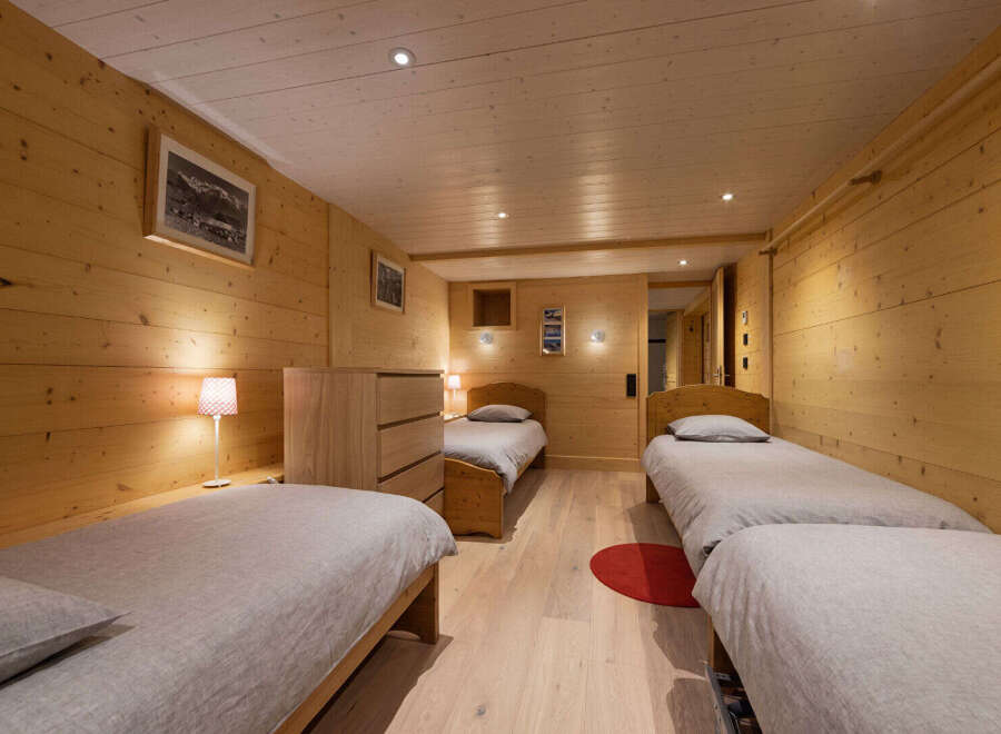 This charming bedroom features three comfortable twin beds, perfect for accommodating family or guests.