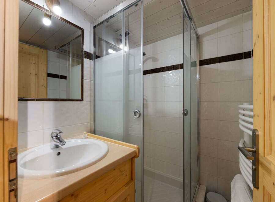 This charming bathroom features a spacious walk-in shower with glass doors, perfect for a refreshing start to your day.