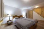 This charming bedroom features two comfortable twin beds with plush grey linens and wooden headboards.