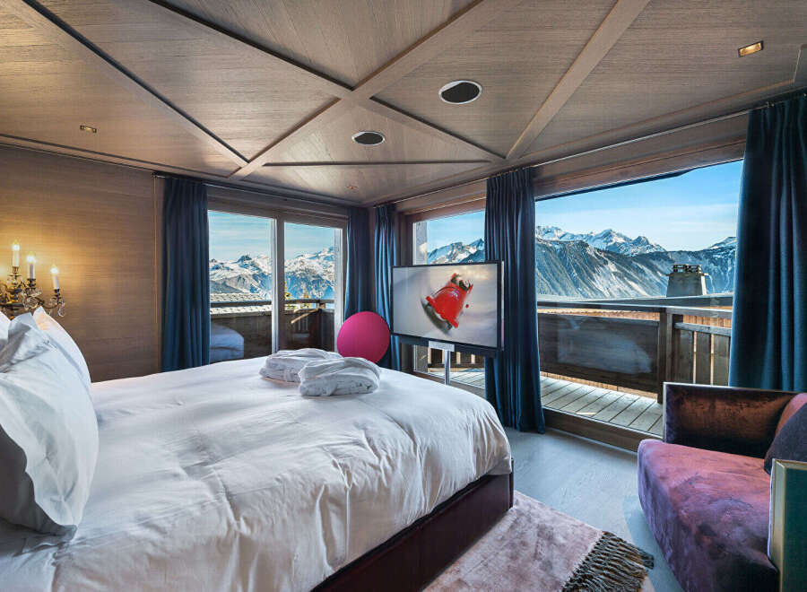 Experience unparalleled luxury in this stunning mountain-view bedroom, featuring a plush king-sized bed, plush bathrobes, and a modern entertainment system.