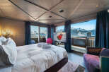Experience unparalleled luxury in this stunning mountain-view bedroom, featuring a plush king-sized bed, plush bathrobes, and a modern entertainment system.