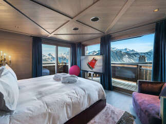 Experience unparalleled luxury in this stunning mountain-view bedroom, featuring a plush king-sized bed, plush bathrobes, and a modern entertainment system.