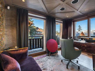 Experience luxury living in this stunning mountain retreat, featuring a sophisticated home office with a rich wood desk and an ergonomic chair.