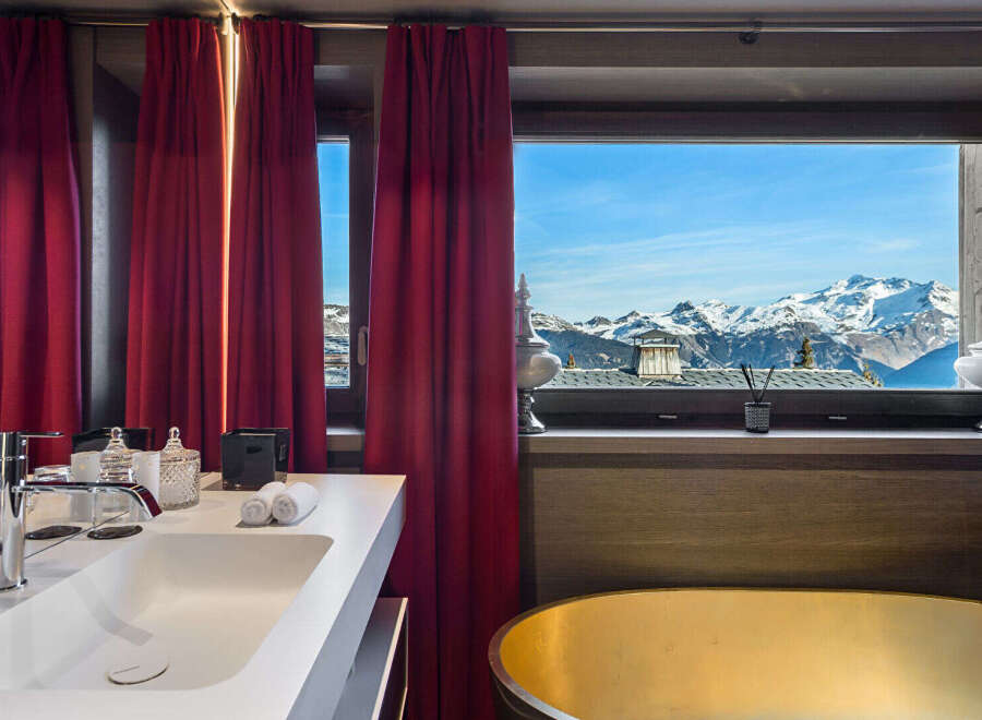 Experience unparalleled luxury with this stunning bathroom featuring a sleek white sink and a magnificent golden bathtub.