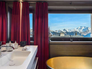 Experience unparalleled luxury with this stunning bathroom featuring a sleek white sink and a magnificent golden bathtub.