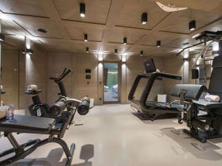 Elevate your fitness routine in this luxurious home gym, featuring state-of-the-art cardio equipment like treadmills and stationary bikes.