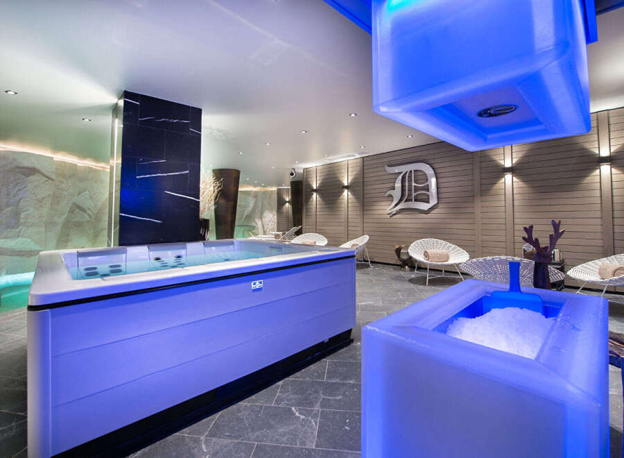 Experience ultimate relaxation in this luxurious spa featuring a vibrant blue-lit jacuzzi and a refreshing ice bath.