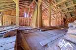 Discover the rustic charm of this unfinished barn, featuring exposed wooden beams and a spacious open floor plan.