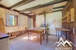 Discover this charming rustic interior featuring exposed wooden beams and a traditional wood-burning stove, perfect for a cozy mountain retreat.