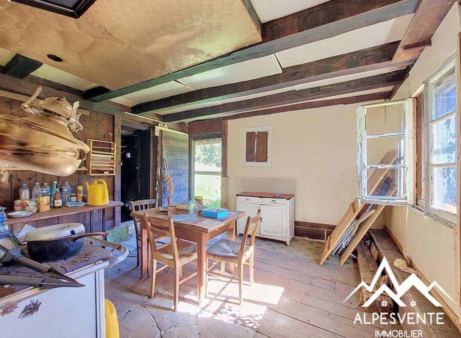 Discover this charming rustic kitchen, featuring exposed wooden beams and a traditional copper pot hanging above the counter.