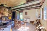 Discover this charming rustic kitchen, featuring exposed wooden beams and a traditional copper pot hanging above the counter.