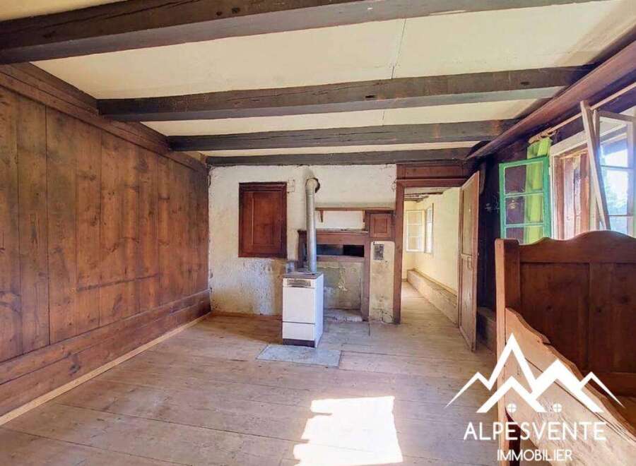 Step into a charming rustic interior featuring exposed wooden beams and rich wood paneling, evoking a cozy and traditional atmosphere.