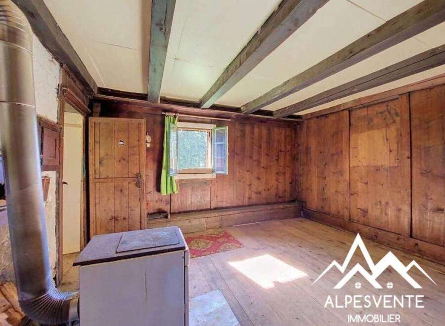 Step into a charming rustic interior featuring exposed wooden beams and warm wood-paneled walls, creating a cozy and inviting atmosphere.