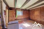 Step into a charming rustic interior featuring exposed wooden beams and warm wood-paneled walls, creating a cozy and inviting atmosphere.