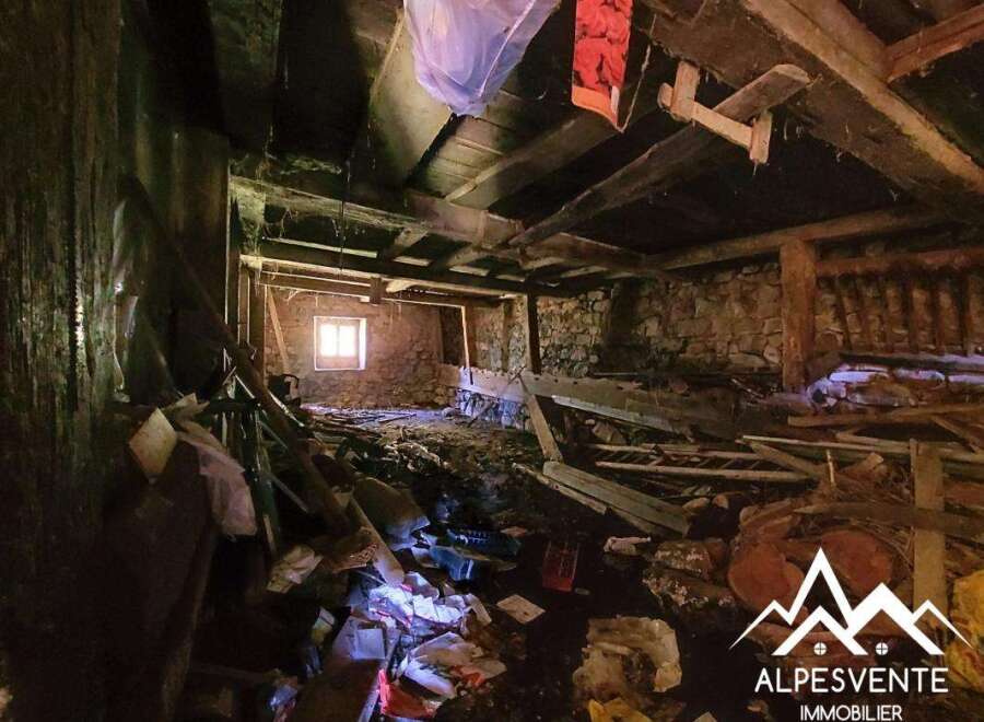 Discover the potential of this rustic property, featuring exposed stone walls and robust wooden beams, offering a unique renovation opportunity.