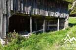 Discover this rustic wooden barn, nestled in a lush green landscape.