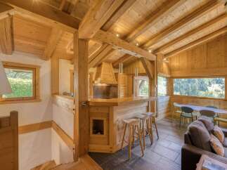 Experience the rustic charm of this mountain chalet, featuring a stunning open-plan living area with a fully equipped kitchen and a cozy dining space.