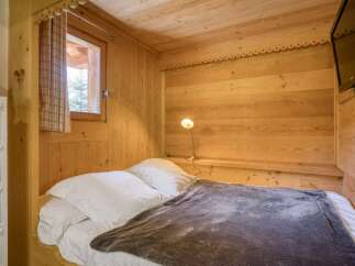 Experience cozy mountain living in this charming bedroom, featuring warm, natural wood paneling throughout.