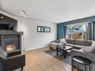 Cozy up by the fireplace in this inviting living room, featuring a large sectional sofa perfect for family gatherings.