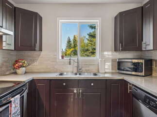 This kitchen boasts dark wood cabinetry and a sleek countertop, complemented by a modern subway tile backsplash.