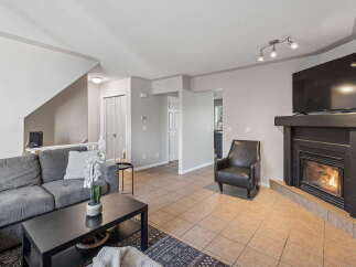Step into this inviting living room, featuring a plush grey sofa perfect for relaxation and a sleek black coffee table.